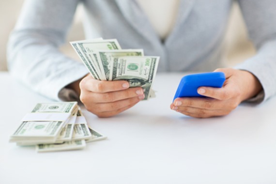 close up of woman hands with smartphone and money