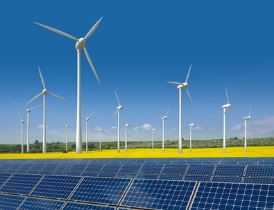 Windkrafträder und Solarmodule in einem Rapsfeld