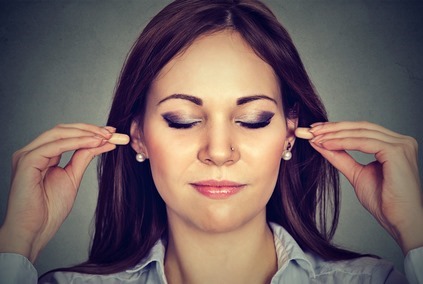 Noise control. Young woman with ear plugs 