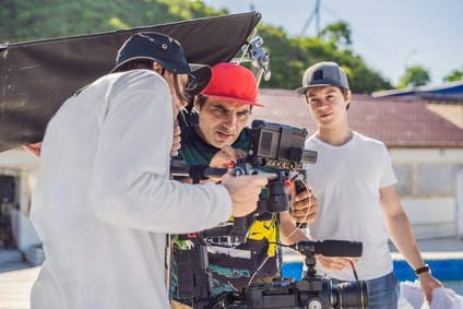 Steadicam operator and his assistant prepare camera and 3-axis stabilizer-gimbal for a commercial shoot Steadicam operator and his assistant prepare camera and 3-axis stabilizer-gimbal for a commercial shoot