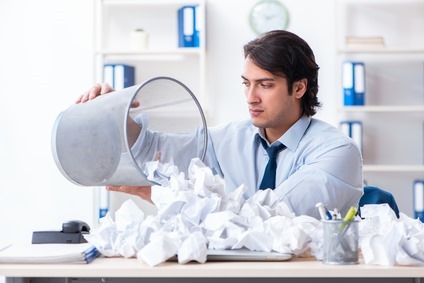 Businessman rejecting new ideas with lots of papers